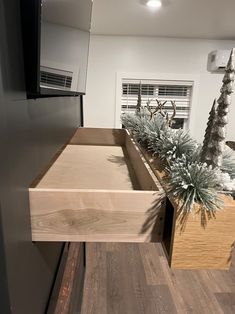 a wooden box with plants in it sitting on top of a counter next to a refrigerator