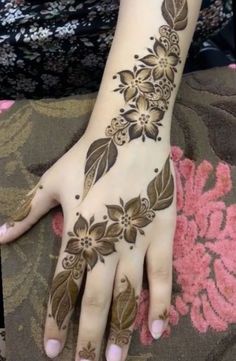 a woman's hand with henna tattoos on it