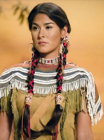 a native american woman with long braids and earrings