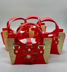 four red and gold bags with bows on them