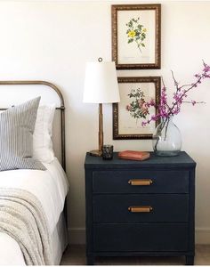 a bed room with a neatly made bed and a night stand next to a nightstand