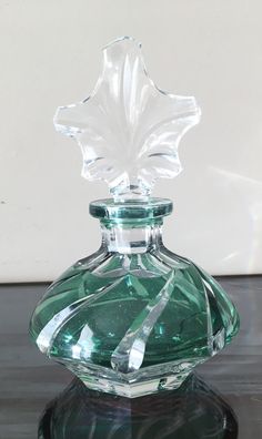 a green glass bottle with a leaf on top