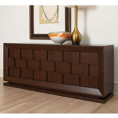 a wooden sideboard sitting on top of a hard wood floor next to a painting