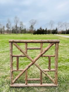 a wooden gate sitting on top of a lush green field