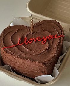 a heart shaped cake with the word i love you written on it in red icing