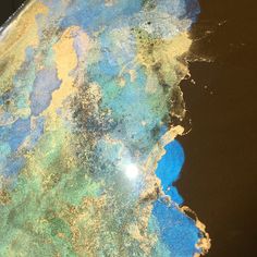 the earth is covered in blue, green and yellow paint on it's surface