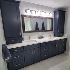 a bathroom with double sinks and blue cabinets