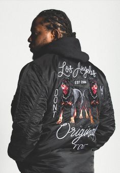 a man wearing a black jacket with two dogs on it and the back of his jacket is