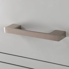 a close up of a bathroom door handle on a white cabinet with drawers in the background