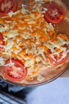 an uncooked pizza with tomatoes and cheese