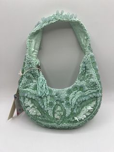 This beautiful shoulder bag is a must-have for any occasion. With a unique crescent shape and stunning mint green exterior, it is sure to turn heads. The bag is handcrafted in India and features intricate beadwork, making it a truly special piece. It has a zip closure and a shoulder strap for easy carrying. The interior is lined with fabric and has ample space for all your essentials. This bag is perfect for travel, weddings, parties, and more. Don't miss out on the chance to own this rare and stunning Tiktok find. I try to ship within 24 hours except on weekends. Smoke free environment. Packaged with care. Green Beaded Shoulder Bag For Daily Use, Cheap Green Beaded Shoulder Bag, Travel Multicolor Beaded Shoulder Bag, Multicolor Beaded Handheld Shoulder Bag, Traditional Green Beaded Bag, Green Exterior, Crescent Shape, Beaded Bag, Beaded Bags