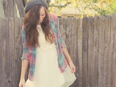 a woman in a white dress and plaid jacket