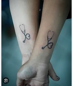 two small tattoos on both wrist and hand, one with a stethoscope