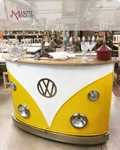 a yellow and white vw bus shaped bar with wine glasses on the counter top