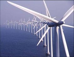 a row of wind turbines in the ocean