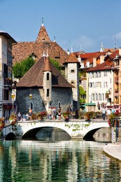 a bridge over a body of water with buildings in the background and people walking on it