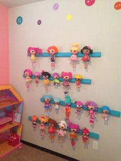 there are many little dolls hanging on the wall in this room, and one shelf is filled with toys