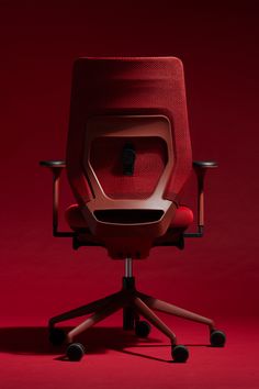 an office chair with red upholstered back and seat, on a red background