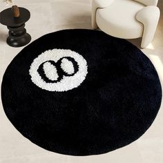 a black rug with white letters on it and a chair in the corner next to it