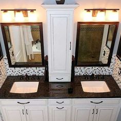 a bathroom with double sinks and two mirrors