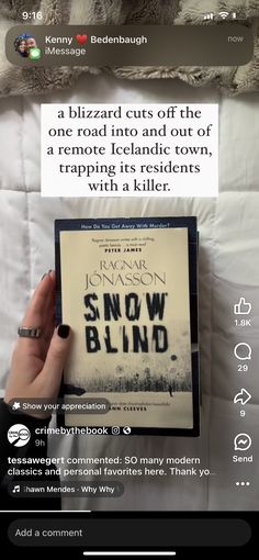 someone holding up a book in their hand on top of a bed with the caption snow blind