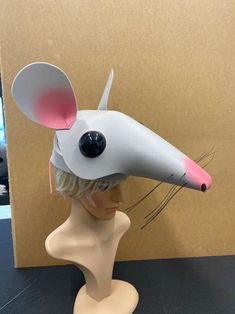 a white and pink mouse hat on top of a mannequin's head