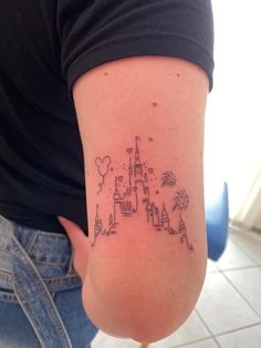 a woman with a tattoo on her arm that has a castle and fireworks in it