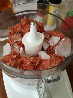 a food processor filled with meat and ice cubes