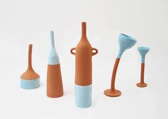 four different colored vases and one with a spoon