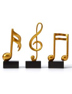 three golden musical notes on black stands