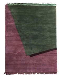 a green and purple rug with fringes on the bottom, in two different colors