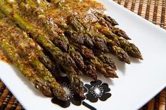 grilled asparagus on a white plate with mustard