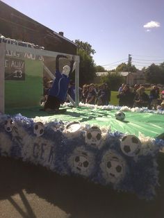 a table with soccer balls on it in front of a group of people