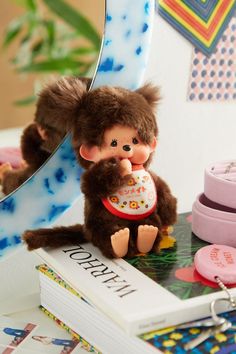 a stuffed monkey is sitting on top of a book