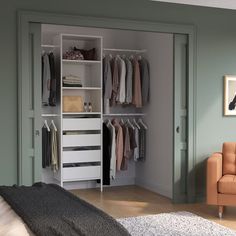 an open closet with clothes on hangers and a couch in the corner next to it