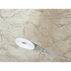 a roll of toilet paper sitting on top of a beige wallpaper covered in swirls