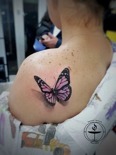 a woman with a pink butterfly tattoo on her shoulder