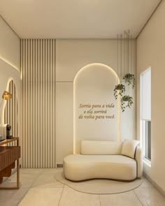 a living room with a white couch and a plant on the wall next to it