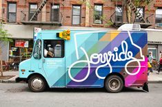 an ice cream truck is parked on the side of the street in front of a brick building