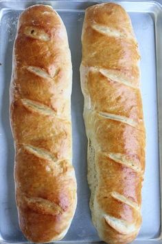 two loaves of bread sitting on top of a pan