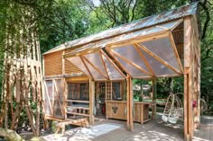 a wooden gazebo sitting on top of a wooden deck next to trees and bushes