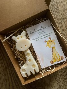 two giraffes are sitting in a box on the floor next to a card