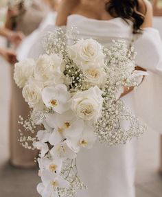 a bride holding a bouquet of white flowers