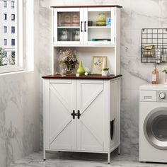 a washer and dryer in a room with marble walls, white cabinets and flooring