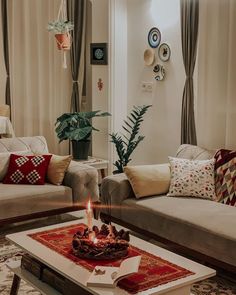 a living room with two couches and a table that has a lit candle on it