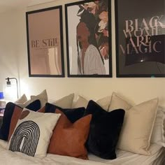 a bed with pillows and pictures on the wall