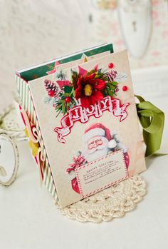 a christmas card with a red poinsettio on it sitting on a doily