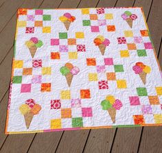 an ice cream themed quilt on a wooden deck