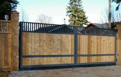 a wooden fence and gate in front of a house