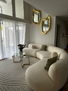 a living room filled with furniture next to a large glass window covered in white curtains